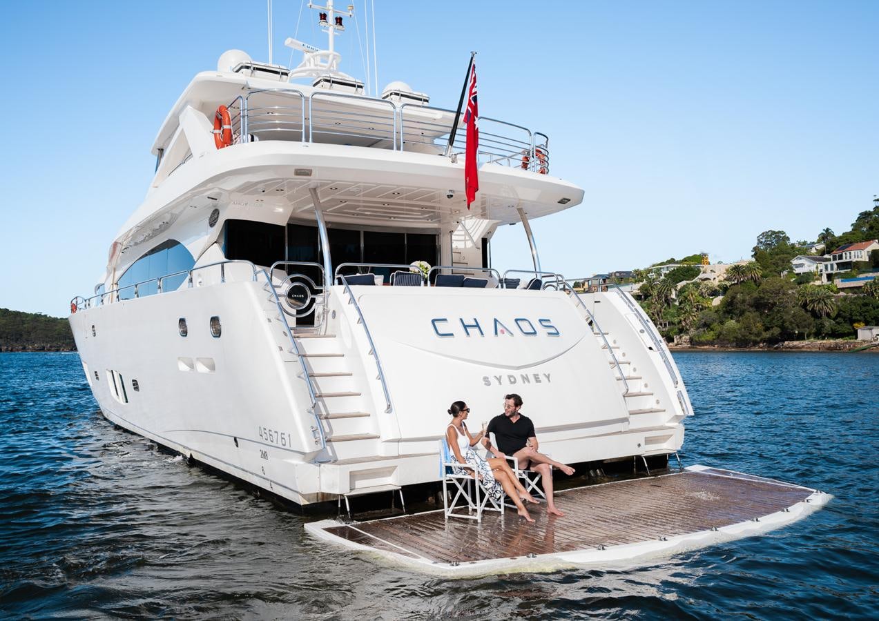 a couple of people sitting on a boat on the water aboard CHAOS Yacht for Sale
