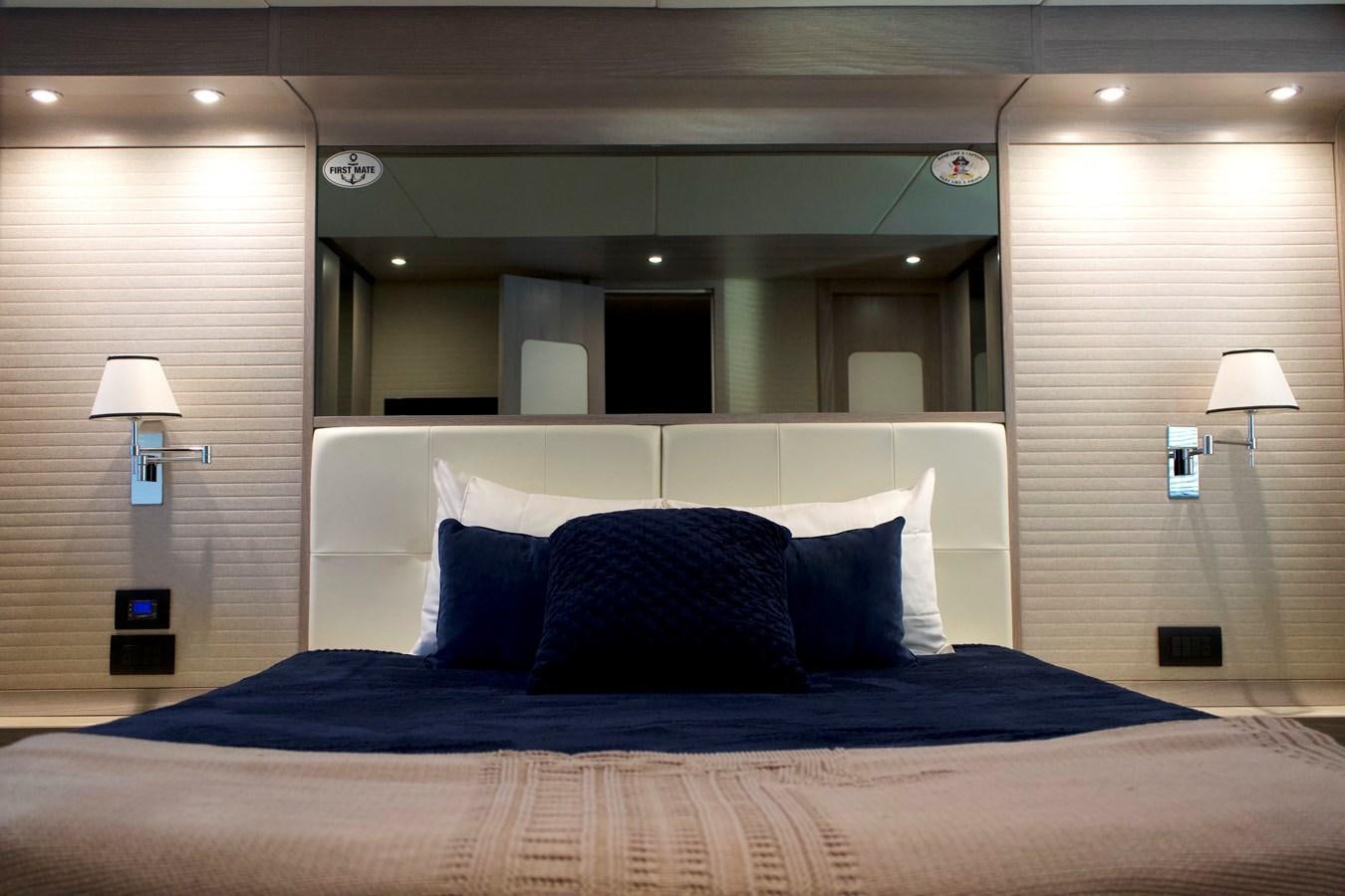 a bed with a blue blanket aboard RAINBOW GODDESS Yacht for Sale