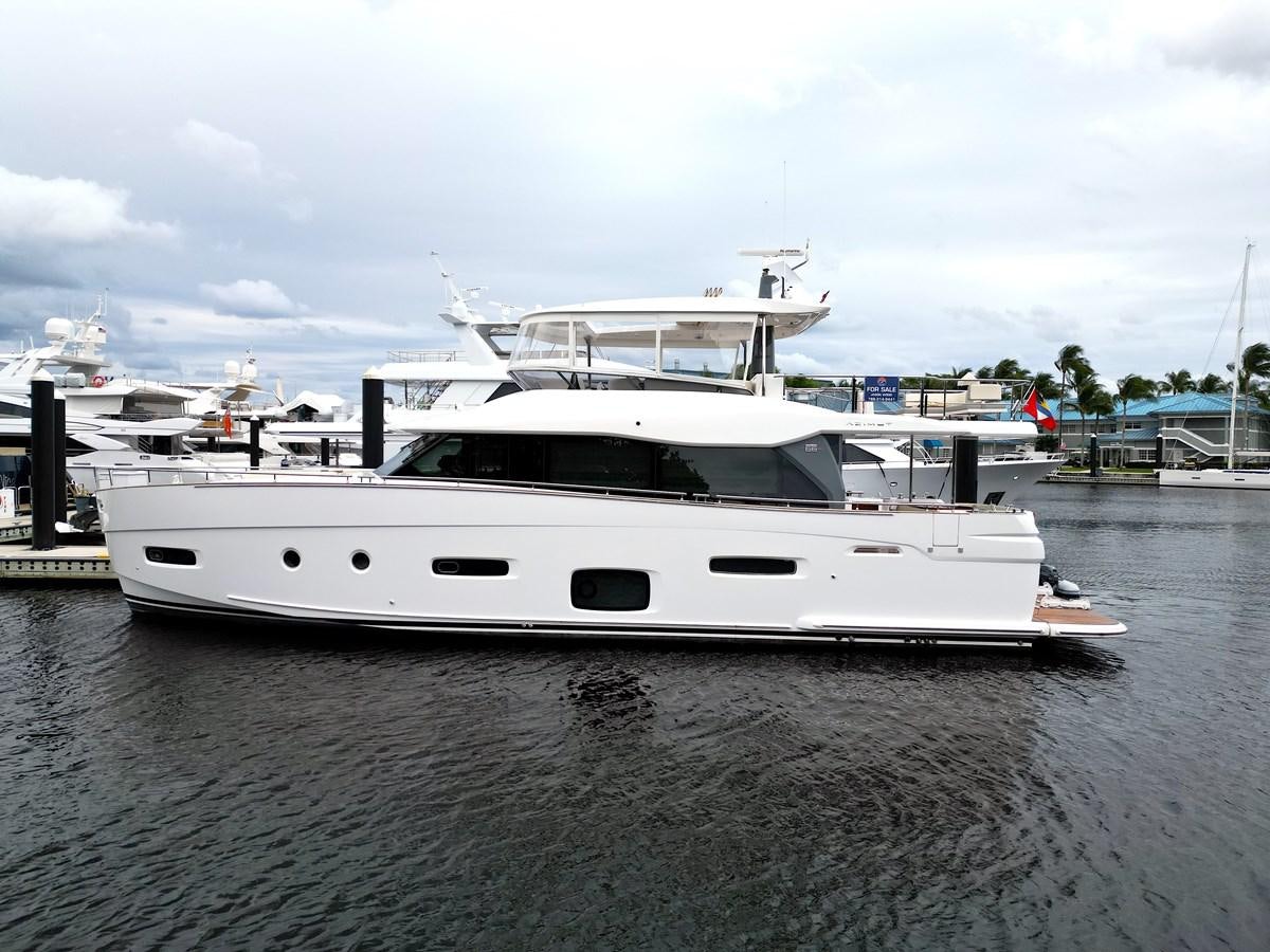 a white yacht in a harbor aboard RAINBOW GODDESS Yacht for Sale