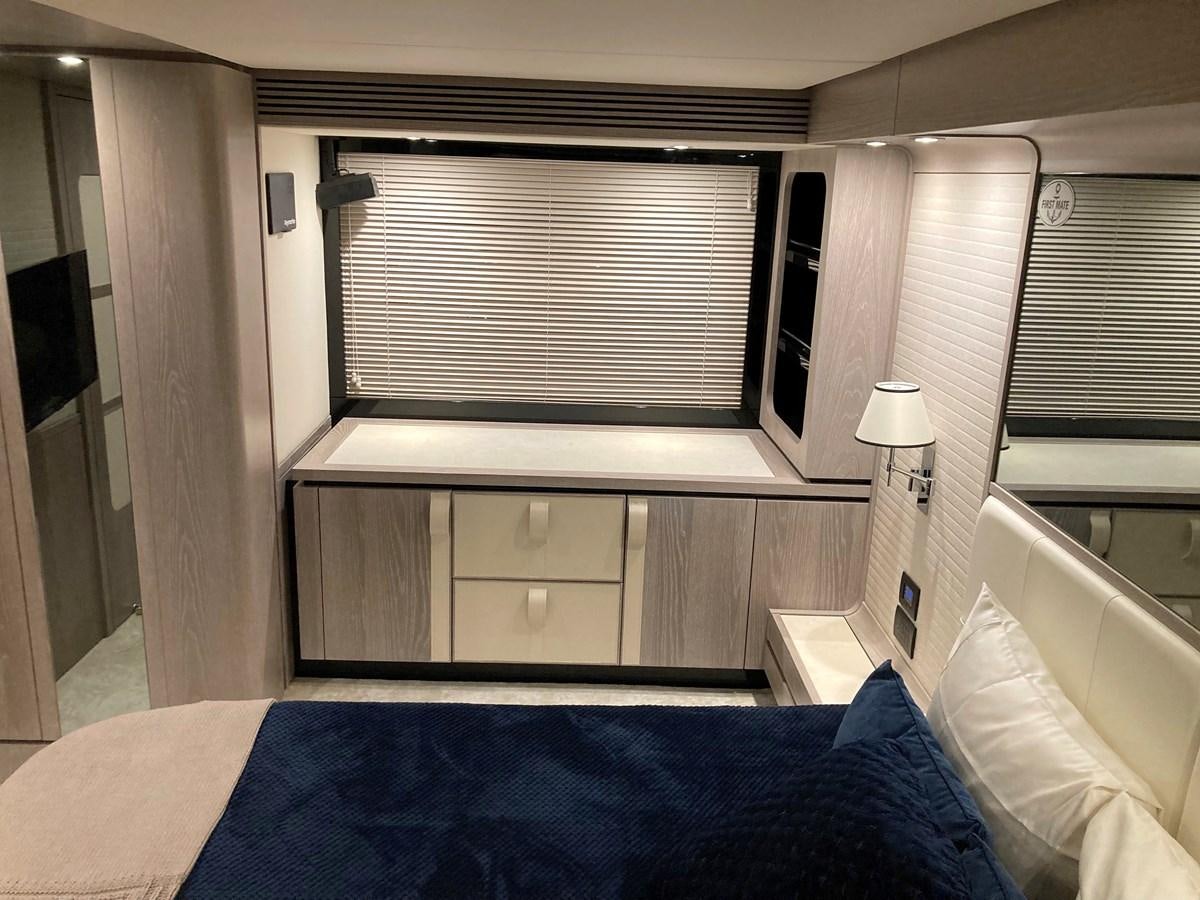 a bedroom with a bed and a window aboard RAINBOW GODDESS Yacht for Sale