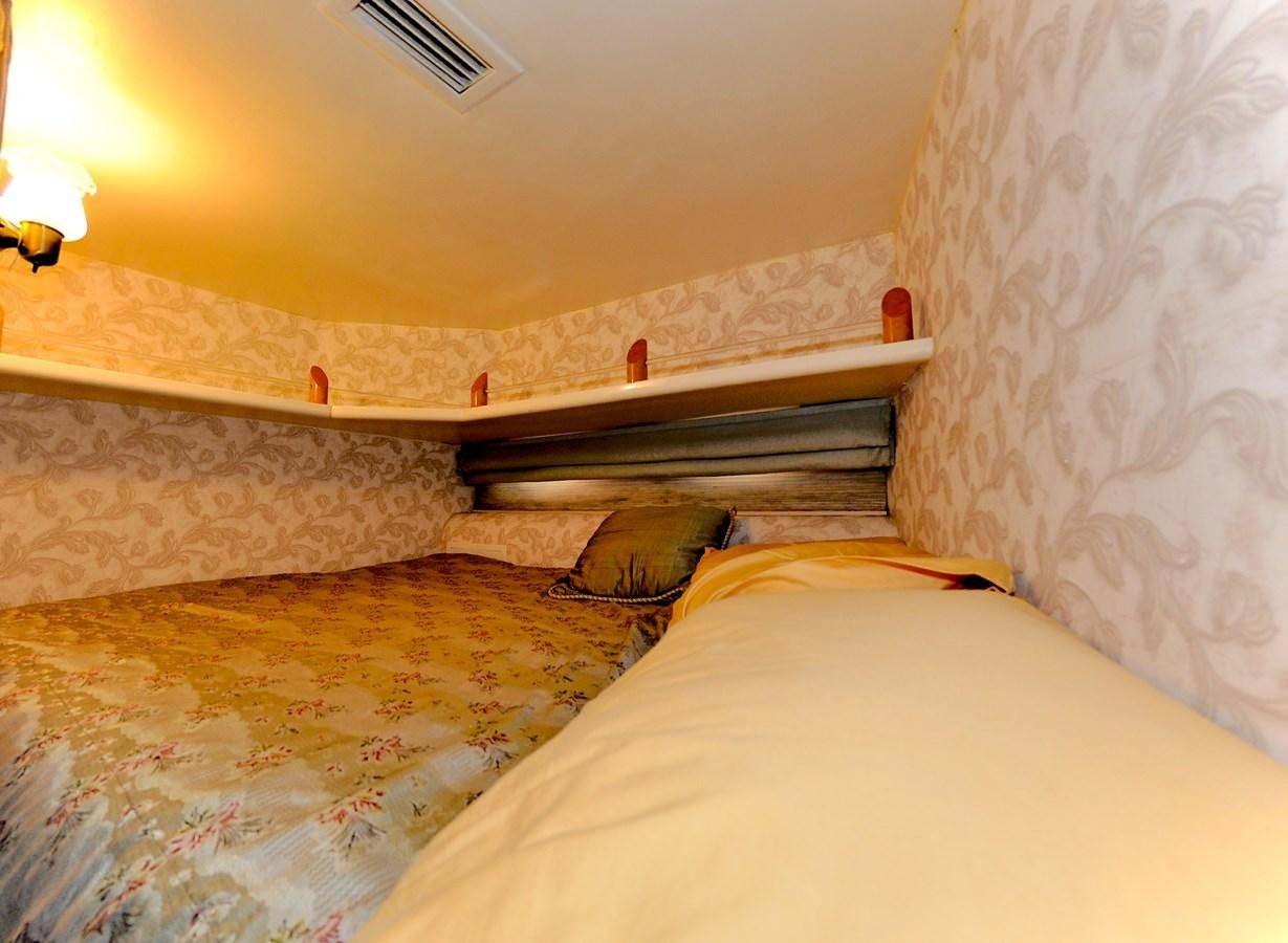 a bed with a wooden headboard aboard CAMY Yacht for Sale