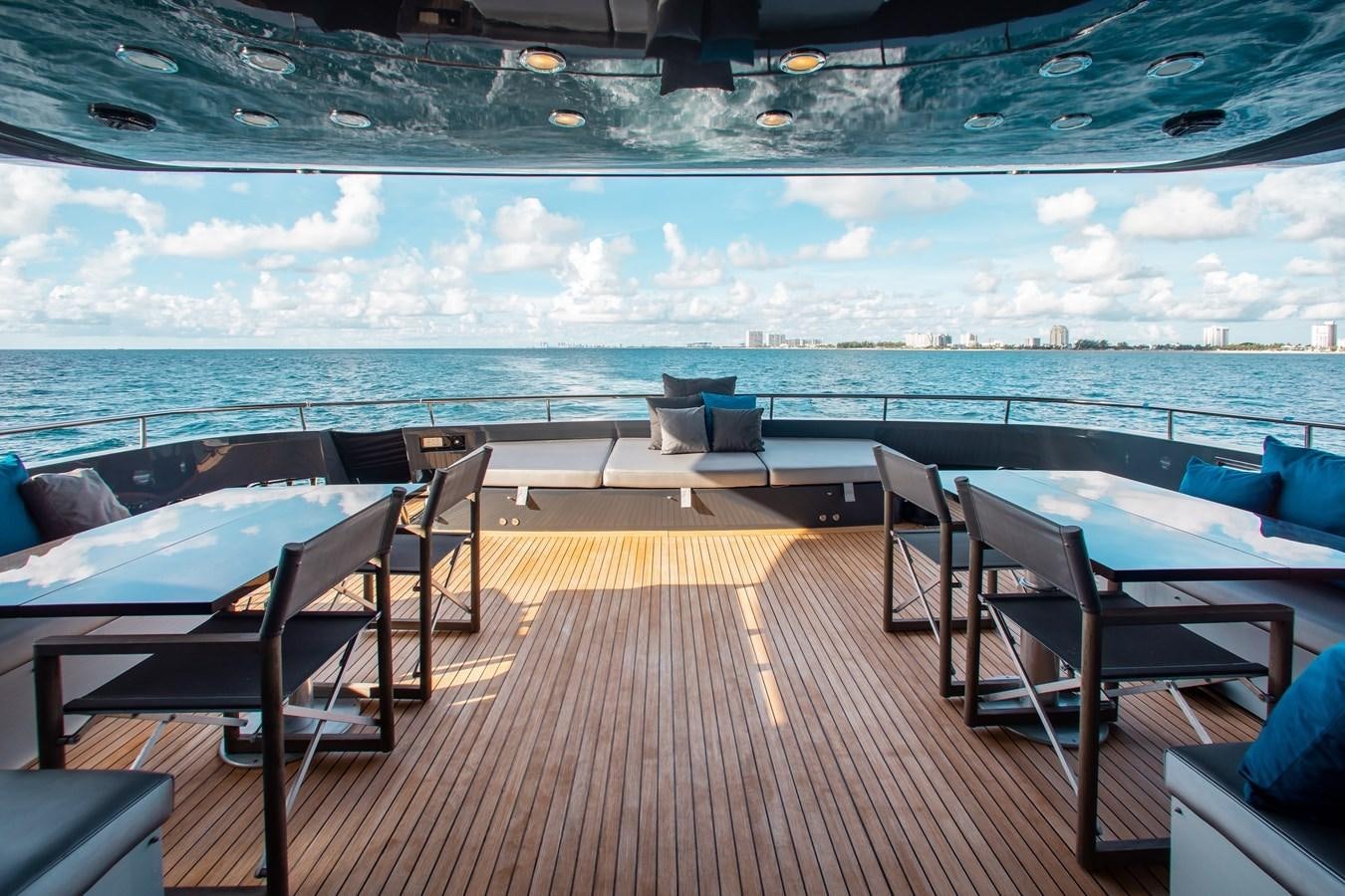 a deck with chairs and a body of water in the background aboard BLUE ICE Yacht for Sale