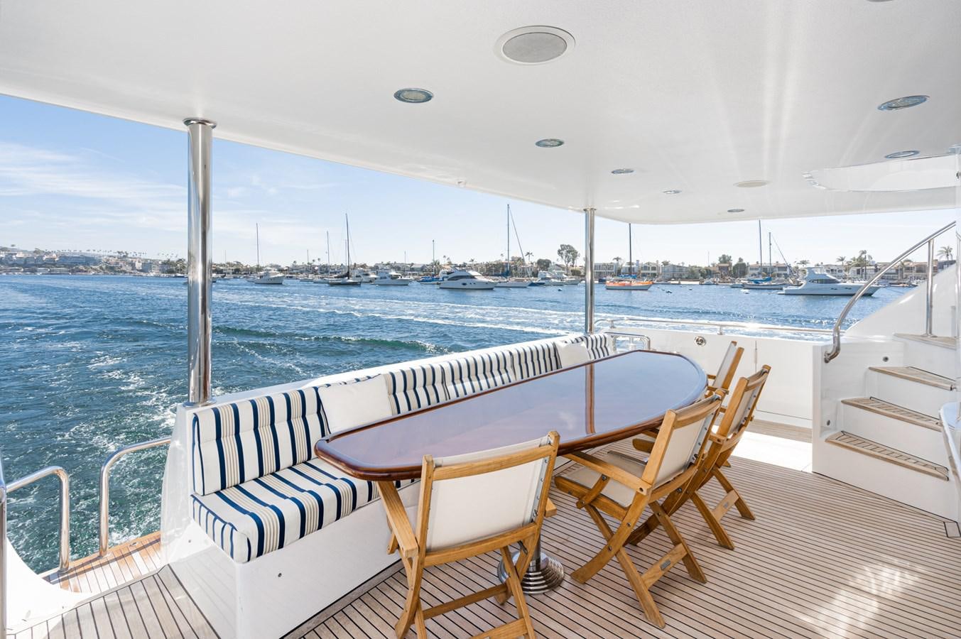 a table and chairs on a deck overlooking a body of water aboard PHANTOM Yacht for Sale