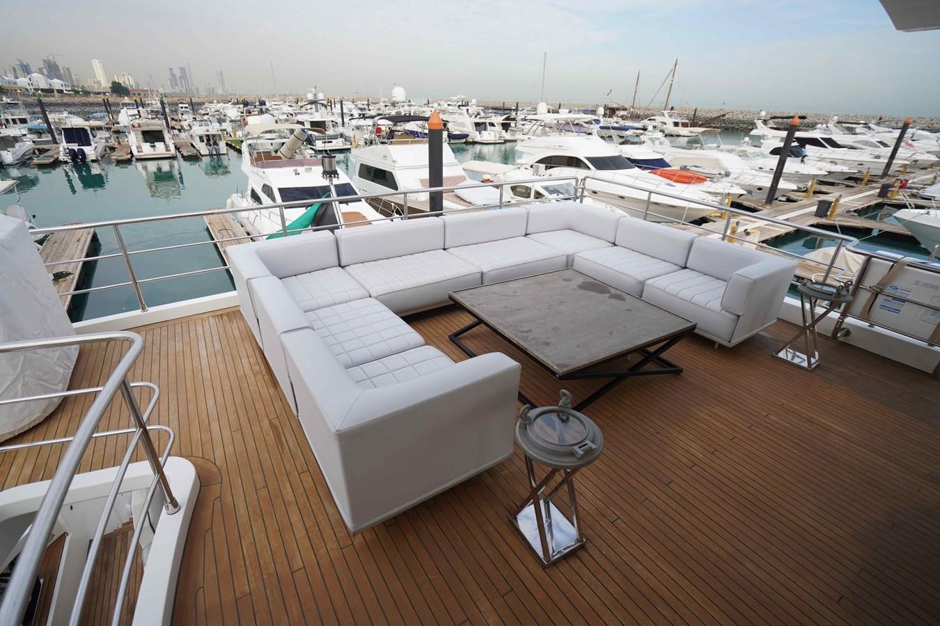 a deck with a boat and a table on it aboard DESIREE Yacht for Sale