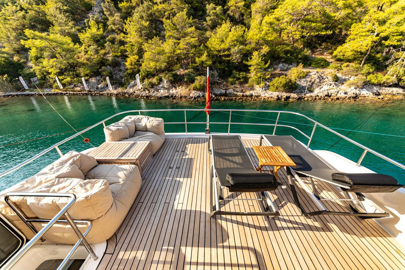 a deck with a dock and a body of water with trees in the background aboard WATER Yacht for Sale
