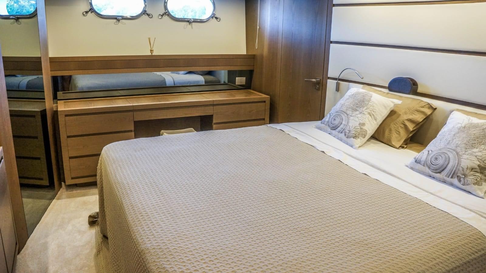 a bed with a white sheet and pillows aboard KUUM Yacht for Sale