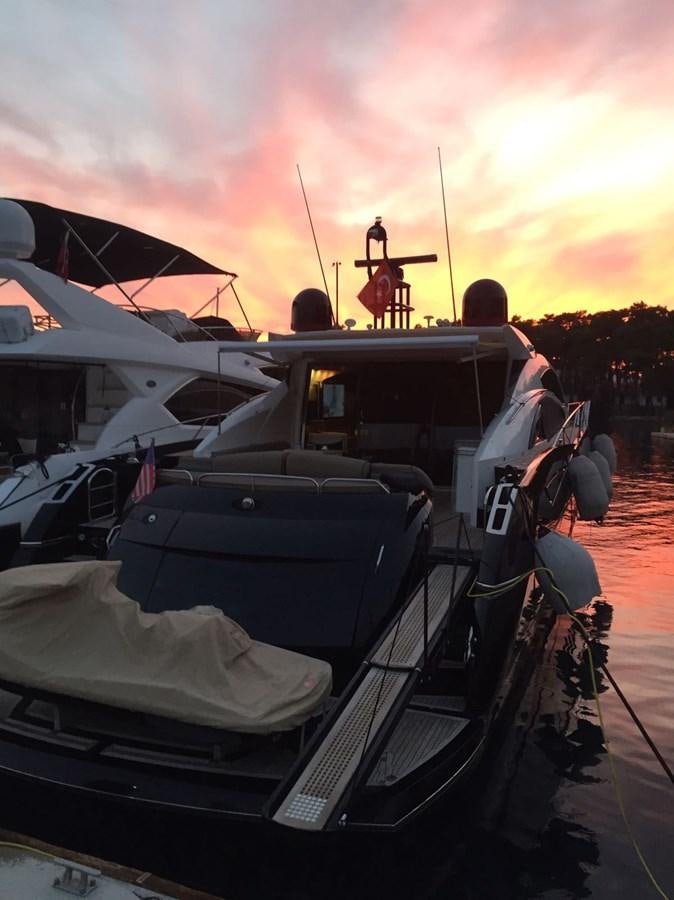 a group of people sitting in a car with a sunset in the background aboard JUNIOR Yacht for Sale