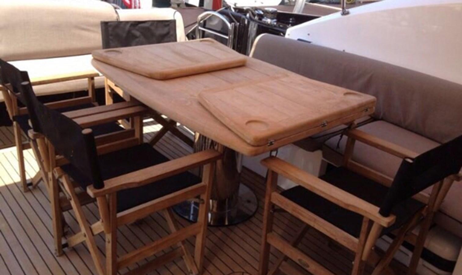 a wooden table with chairs aboard JUNIOR Yacht for Sale