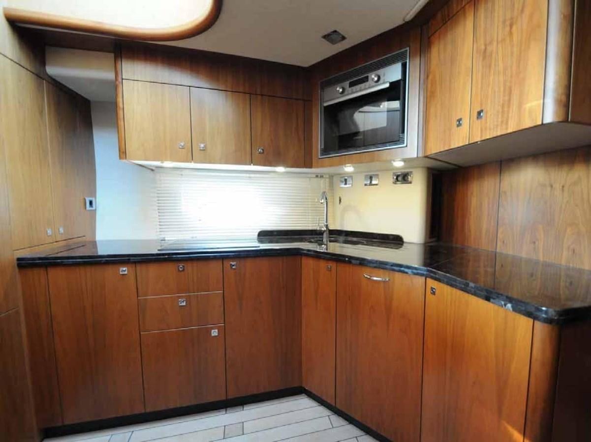 a kitchen with wooden cabinets aboard JUNIOR Yacht for Sale