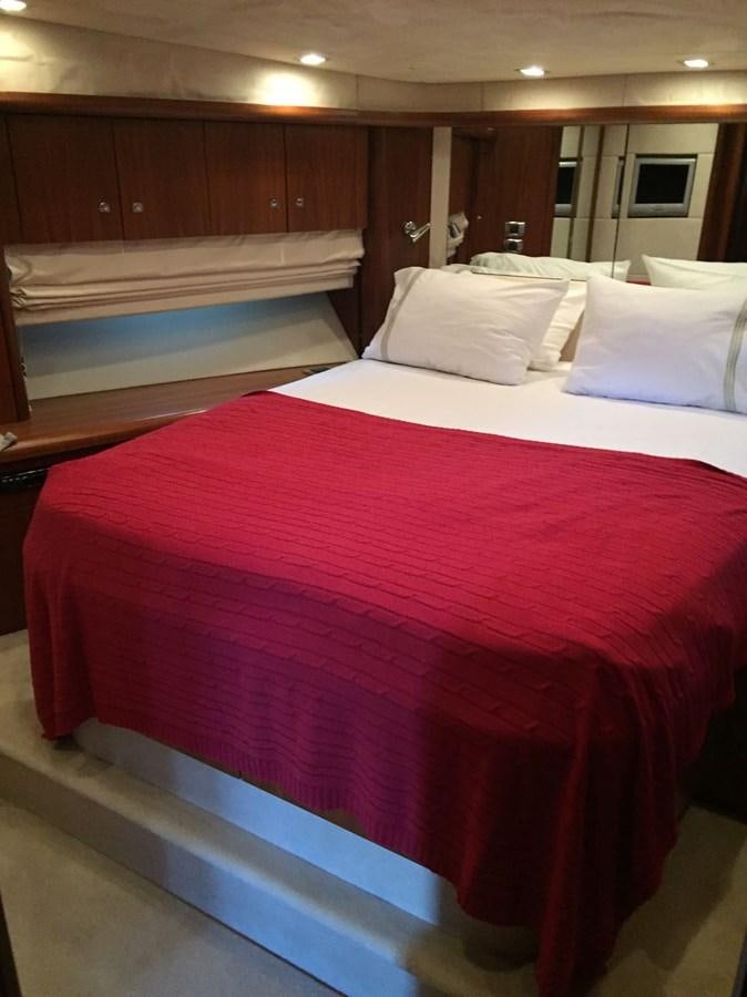 a bed with red sheets aboard JUNIOR Yacht for Sale