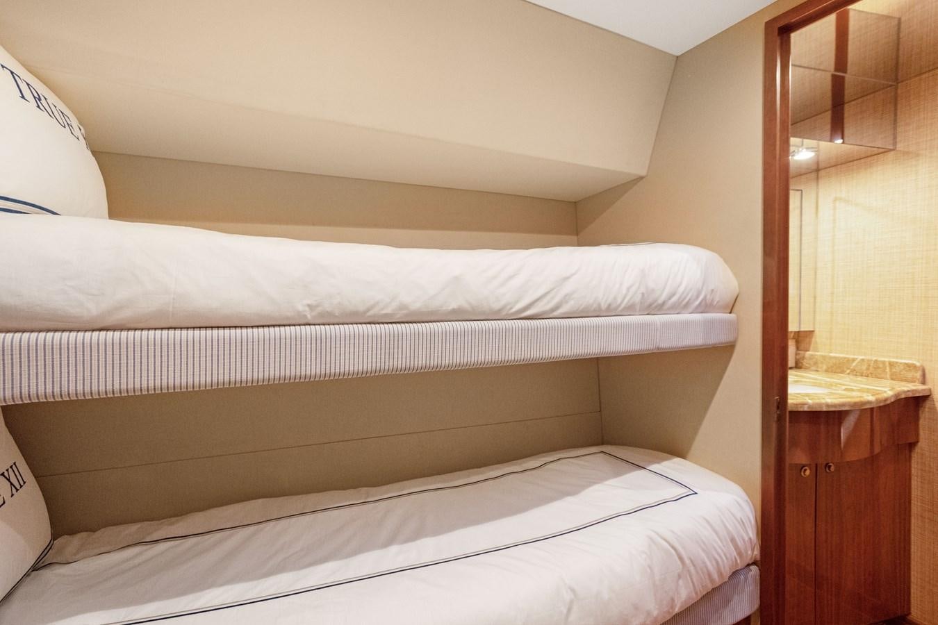 a bed with white sheets aboard TRUE XII Yacht for Sale