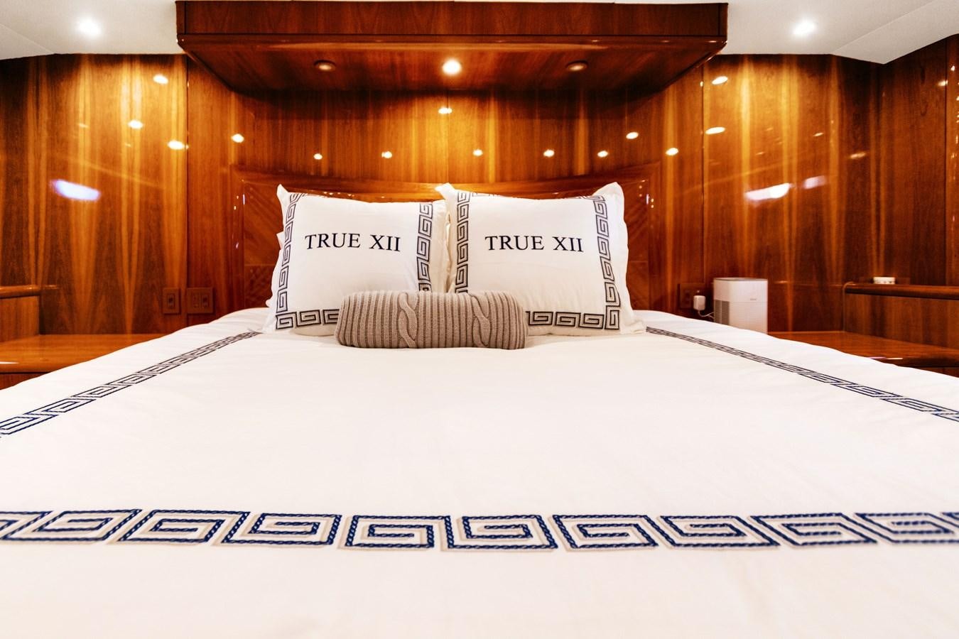 a bed with white sheets aboard TRUE XII Yacht for Sale