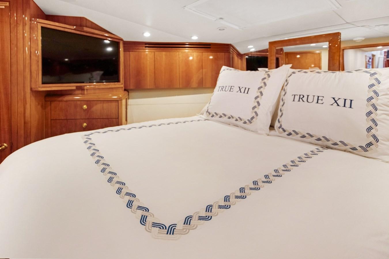 a bed with white sheets and pillows aboard TRUE XII Yacht for Sale