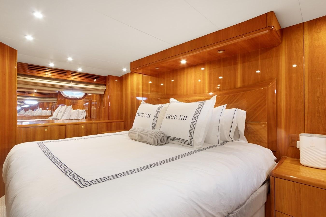 a bed with white sheets aboard TRUE XII Yacht for Sale