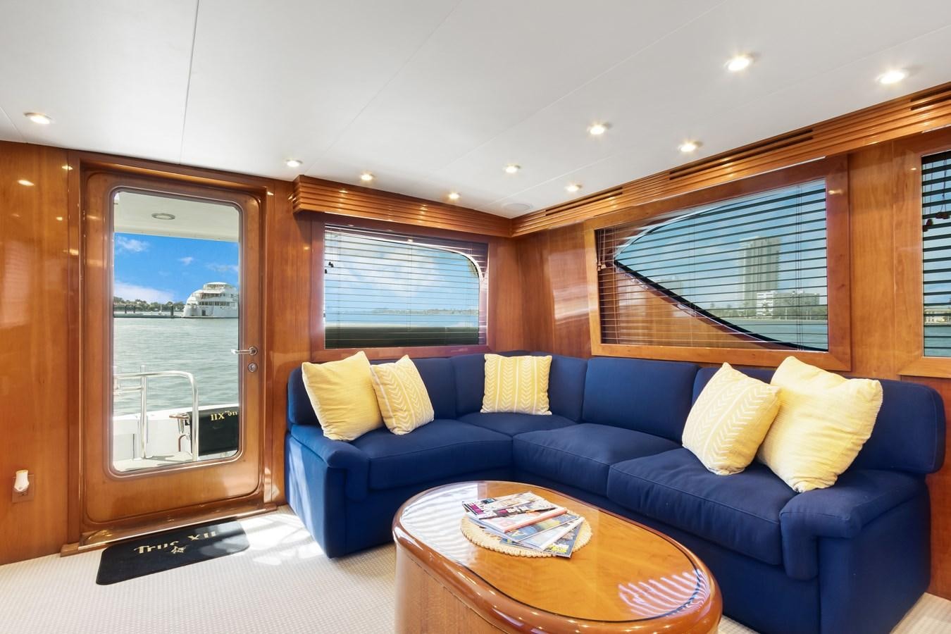 a living room with a blue couch aboard TRUE XII Yacht for Sale