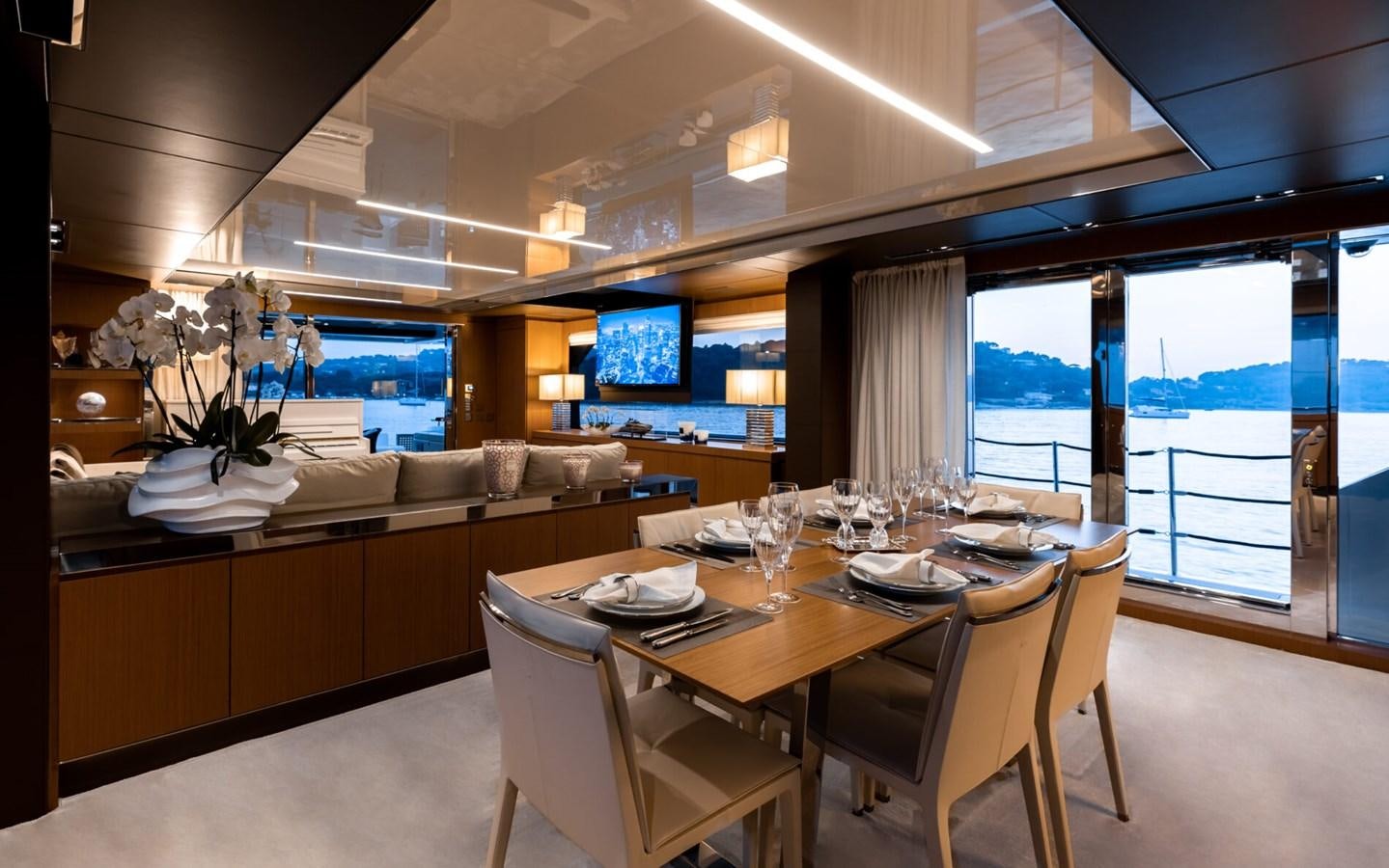 a large room with a table and chairs aboard RAPH SEVEN II Yacht for Sale