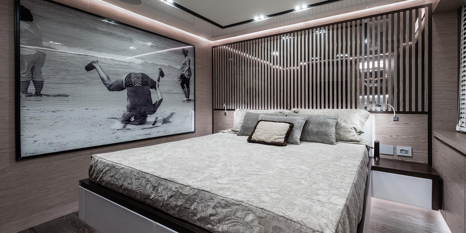 a room with a bed and a painting on the wall aboard ZOUT Yacht for Sale