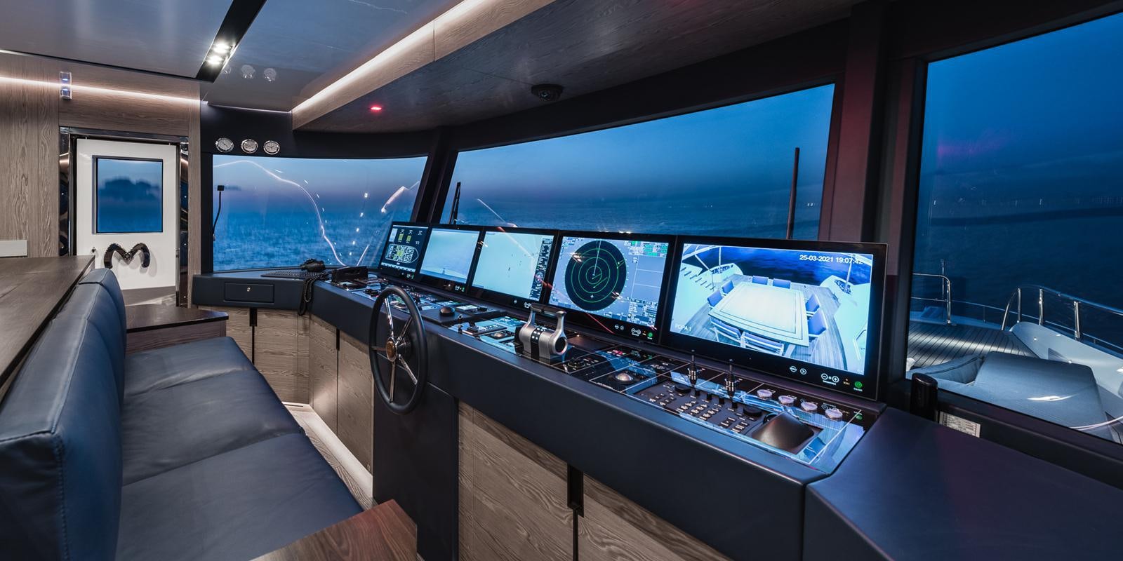 a room with a row of computer screens and a couch aboard ZOUT Yacht for Sale