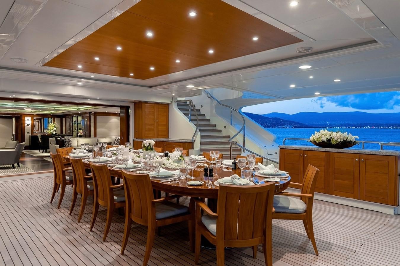 a large dining table in a large room with a large swimming pool aboard SEANNA Yacht for Sale