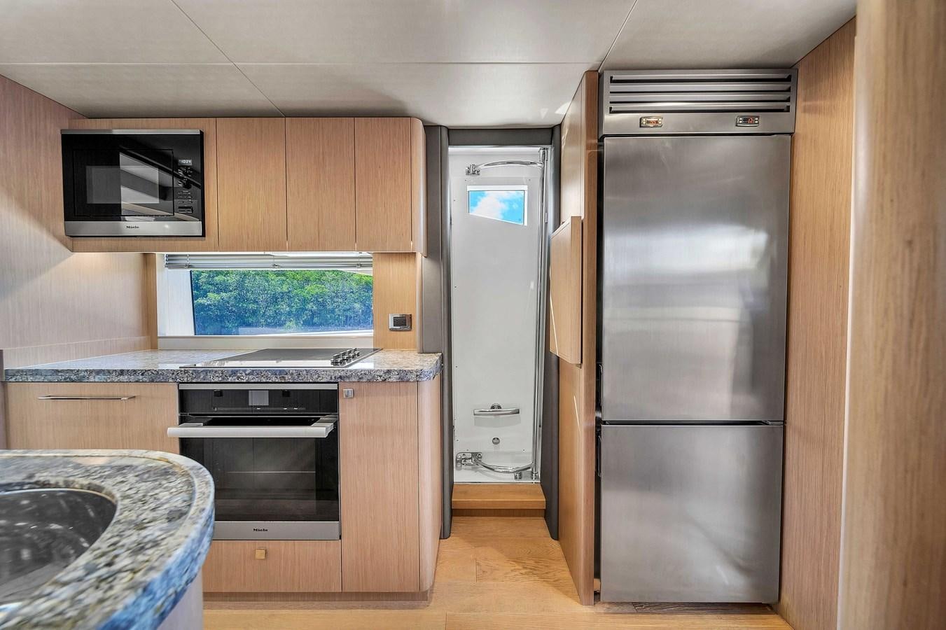 a kitchen with a refrigerator and a microwave aboard 86 Yacht for Sale