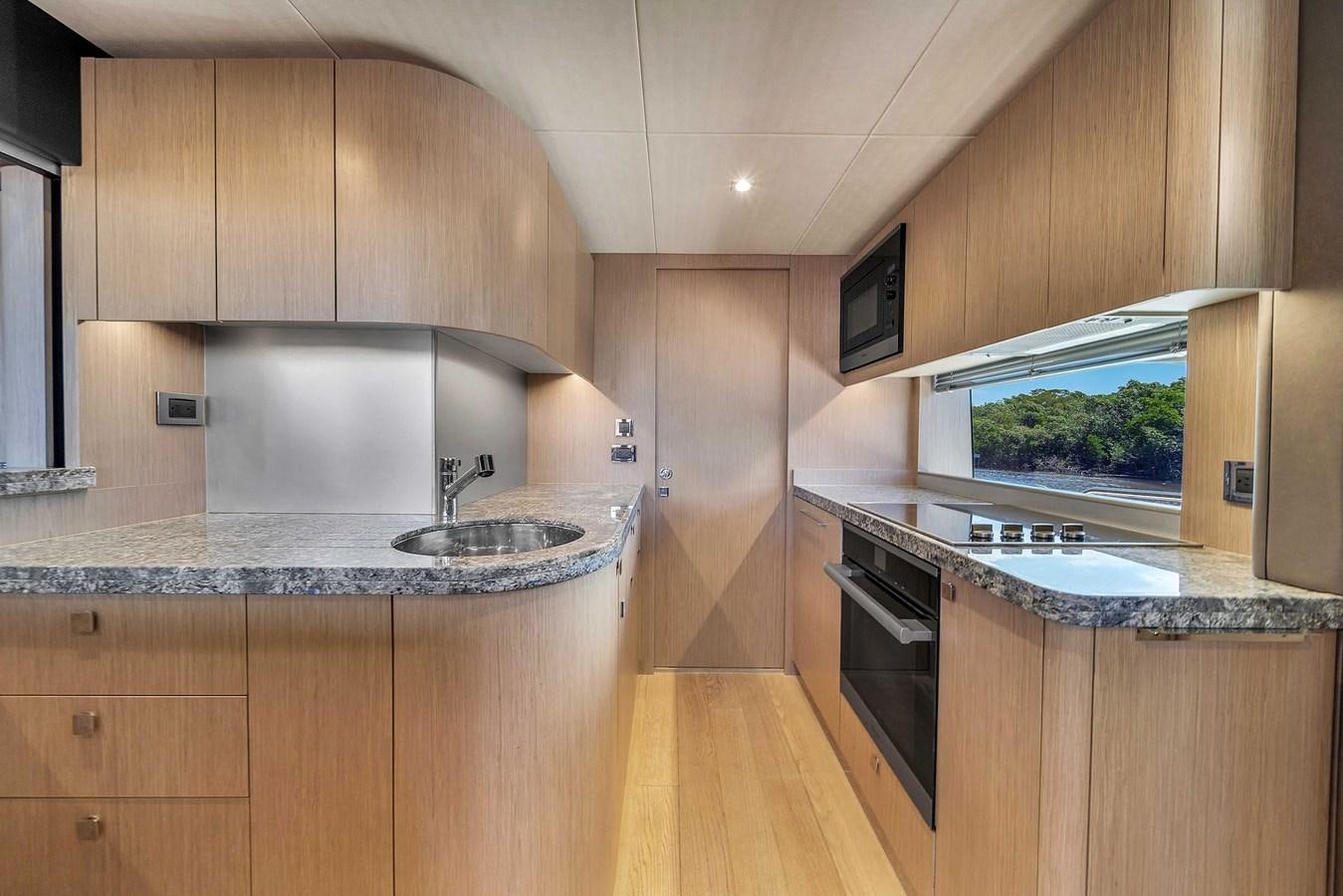a kitchen with wooden cabinets aboard 86 Yacht for Sale