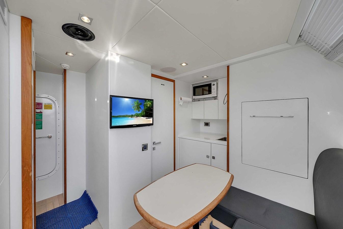 a room with a table and a tv aboard 86 Yacht for Sale