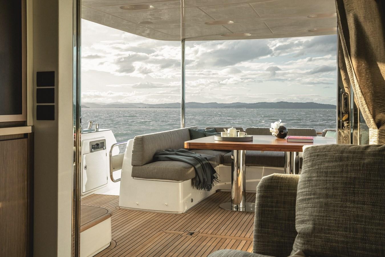 a room with a table and couches aboard 2023 MAGELLANO 66 Yacht for Sale