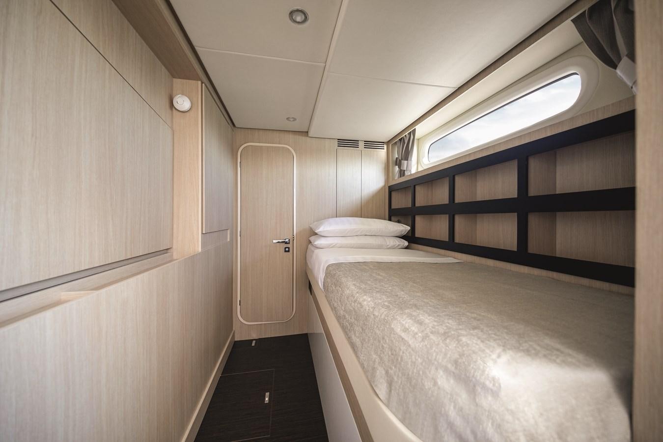 a room with a bed and a window aboard 2023 MAGELLANO 66 Yacht for Sale