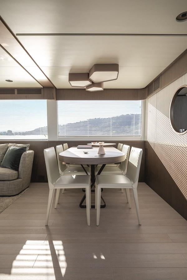 a room with a table and chairs aboard 2023 MAGELLANO 66 Yacht for Sale