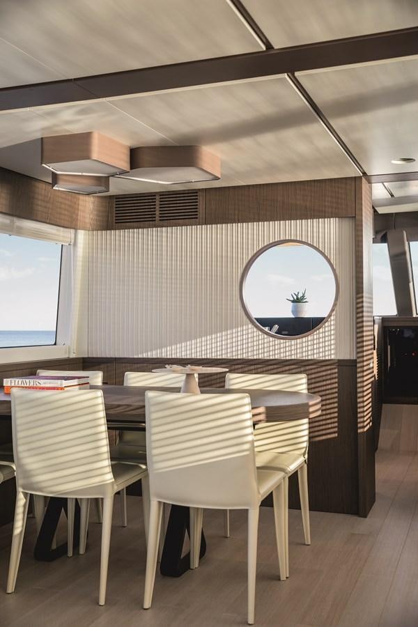 a room with a table and chairs aboard 2023 MAGELLANO 66 Yacht for Sale