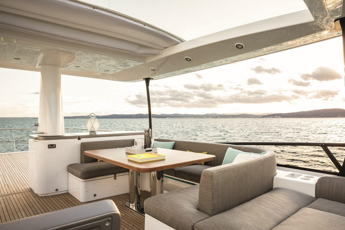 a room with a couch and a table and a view of the ocean aboard 2023 MAGELLANO 66 Yacht for Sale