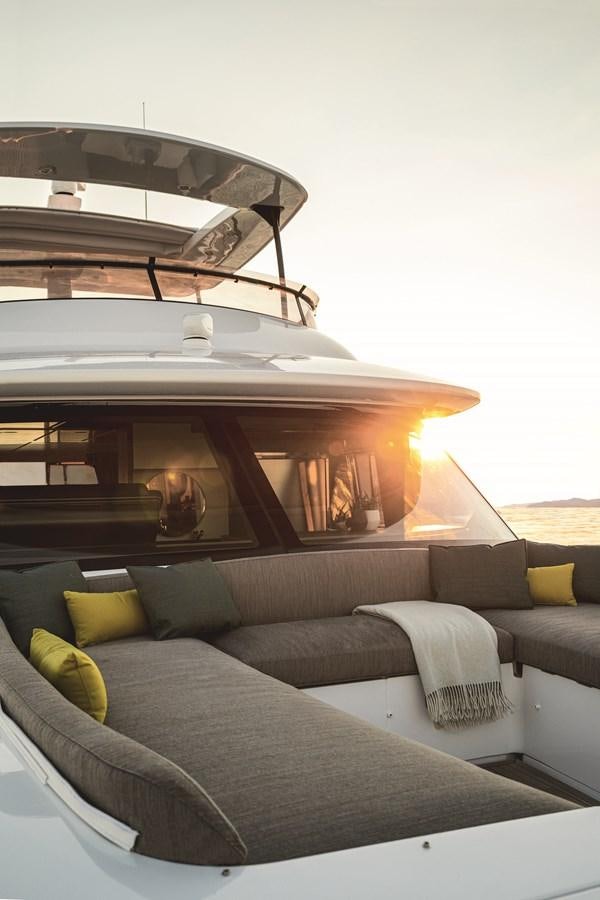 a couch with a table and a bed in front of it aboard 2023 MAGELLANO 66 Yacht for Sale