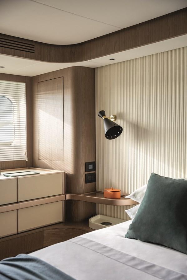 a bedroom with a bed and a lamp aboard 2023 MAGELLANO 66 Yacht for Sale