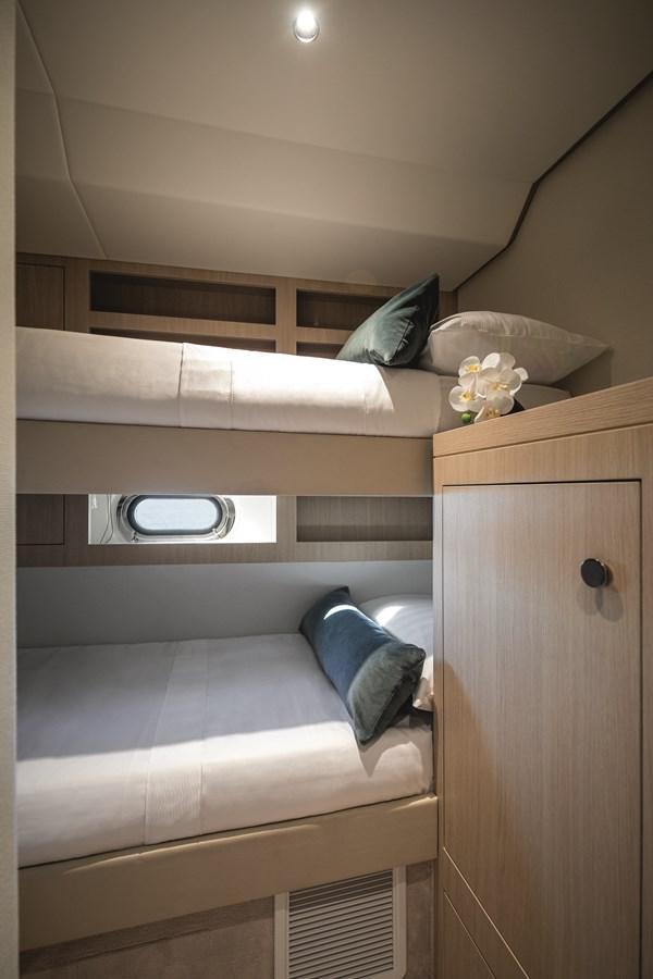 a bed with a white bed and a white pillow aboard 2023 MAGELLANO 66 Yacht for Sale