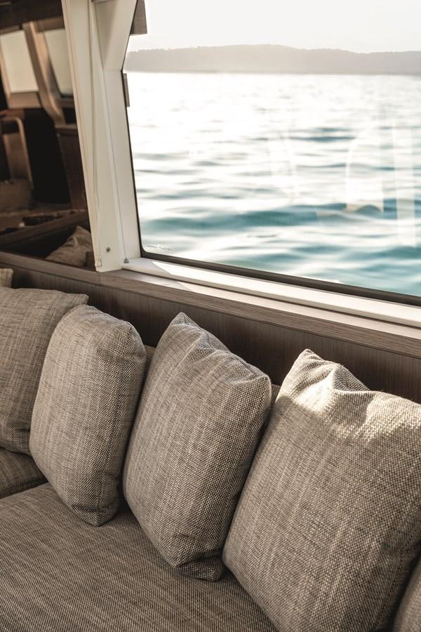 a couch and a window aboard 2023 MAGELLANO 66 Yacht for Sale