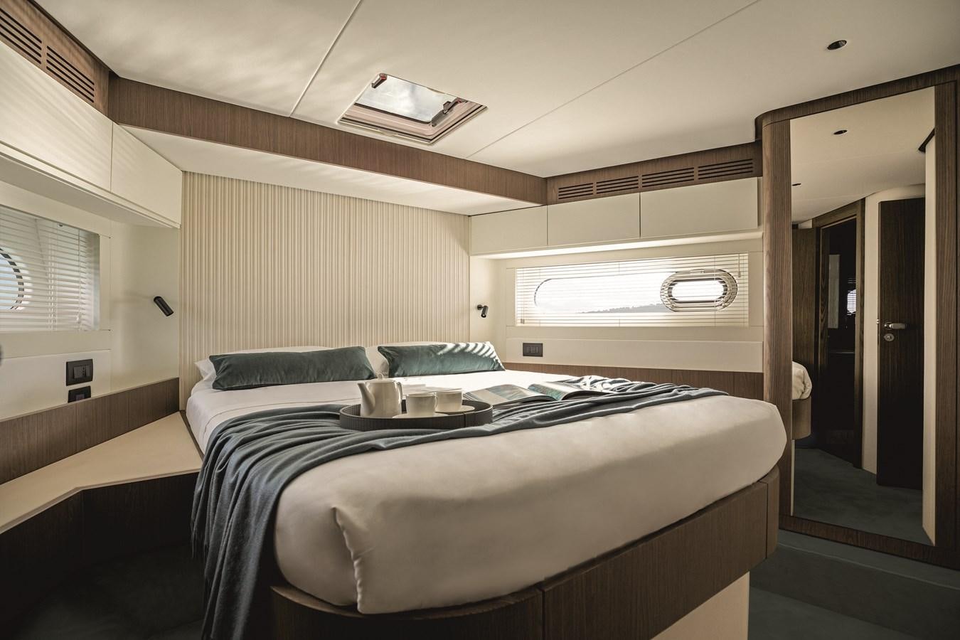 a room with a bed and a television on the wall aboard 2023 MAGELLANO 66 Yacht for Sale