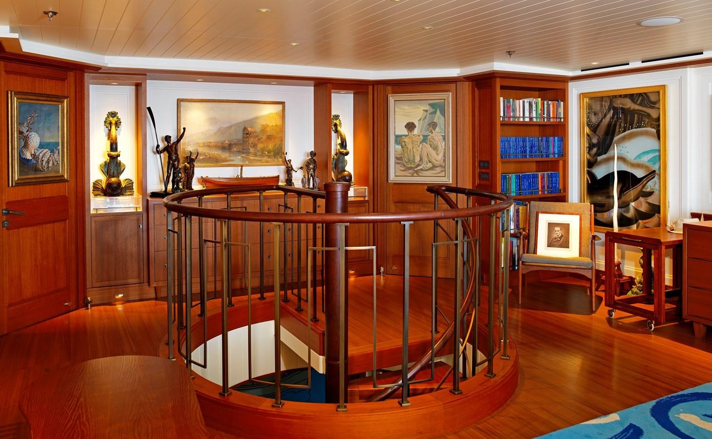 a room with a table and bookshelves aboard MESERRET II Yacht for Sale