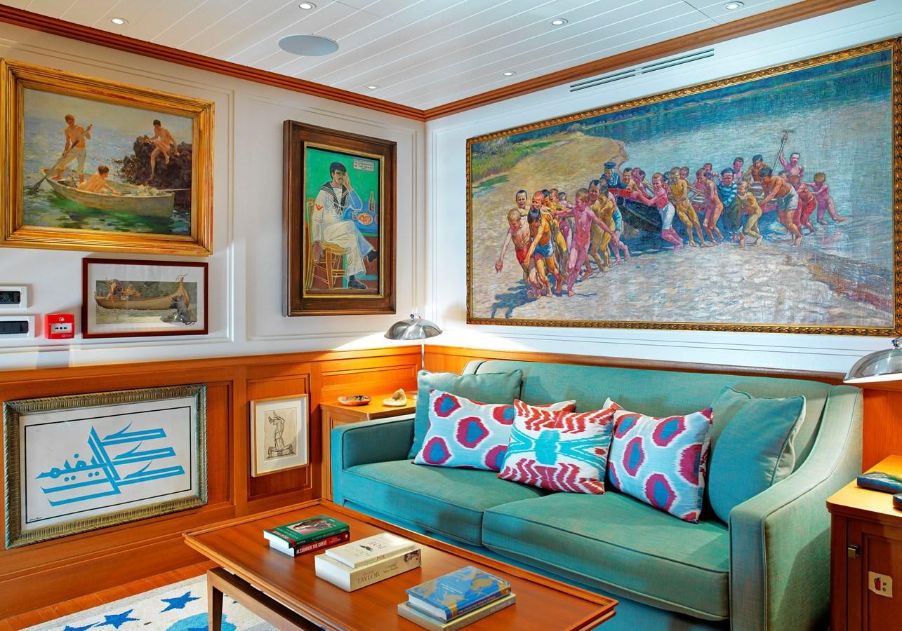 a living room with a couch and paintings on the wall aboard MESERRET II Yacht for Sale