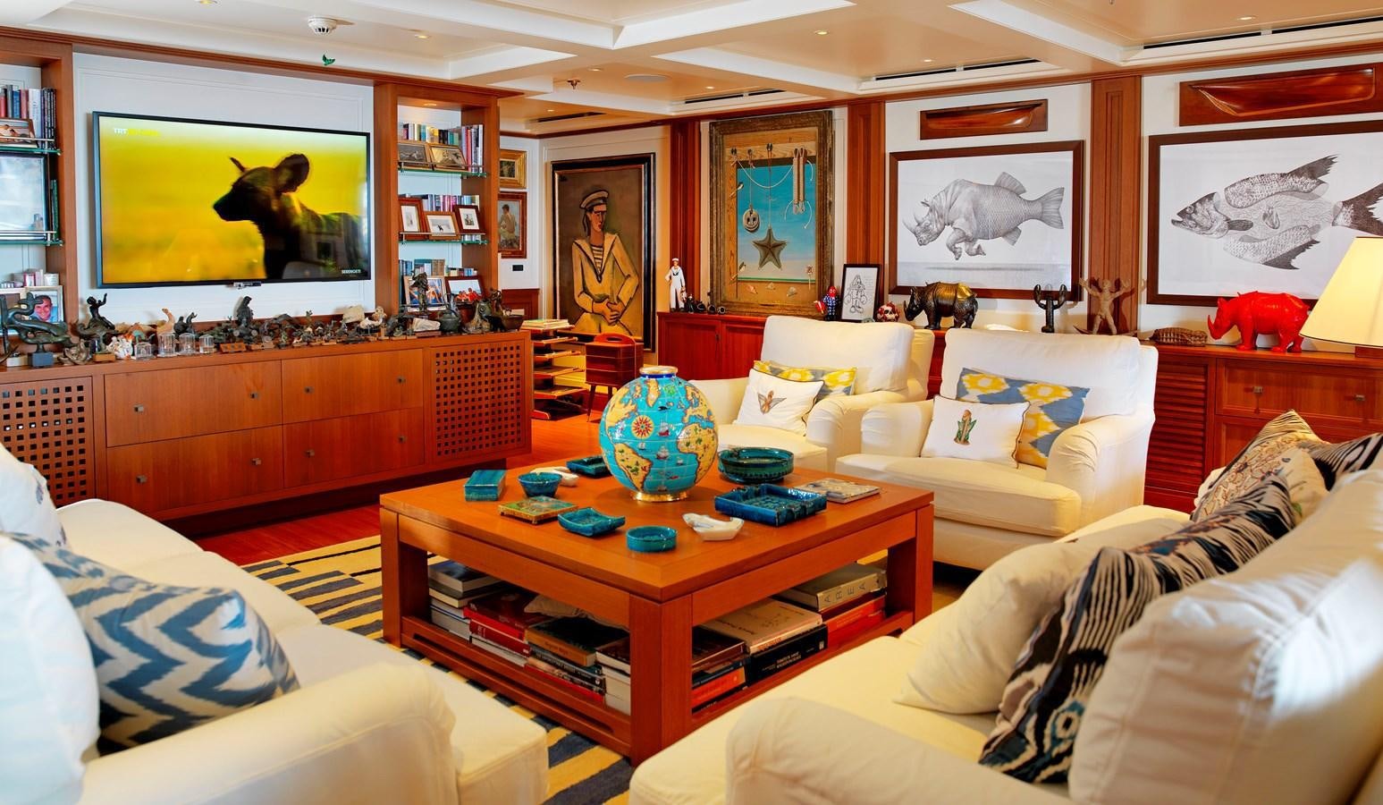 a living room with a table and couches aboard MESERRET II Yacht for Sale