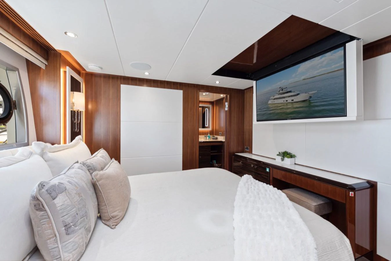 a bed with white sheets and pillows aboard EVERGLADE Yacht for Sale