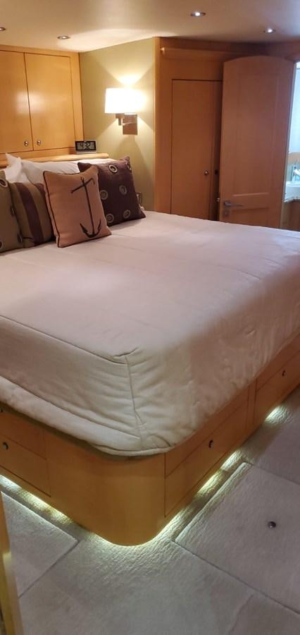a bed with a white sheet aboard RUMBERA Yacht for Sale