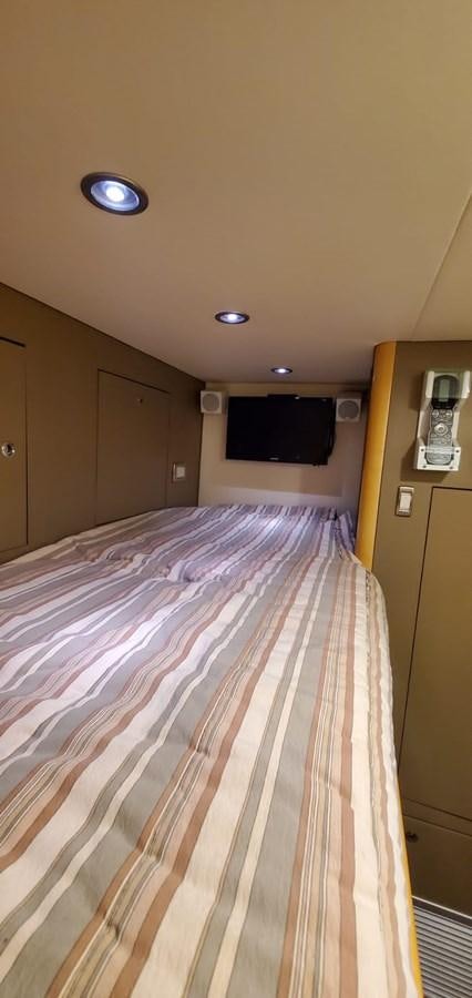 a bed with a blue and white comforter aboard RUMBERA Yacht for Sale