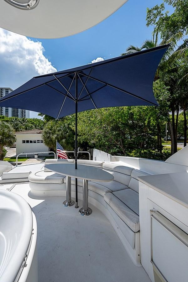 a table and umbrella on a patio aboard FINALLY Yacht for Sale