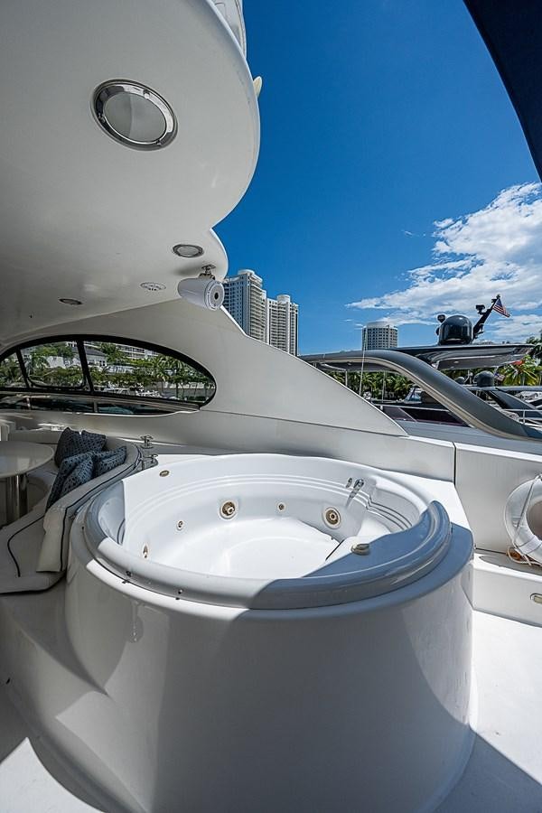 a white boat with a circular object on it aboard FINALLY Yacht for Sale