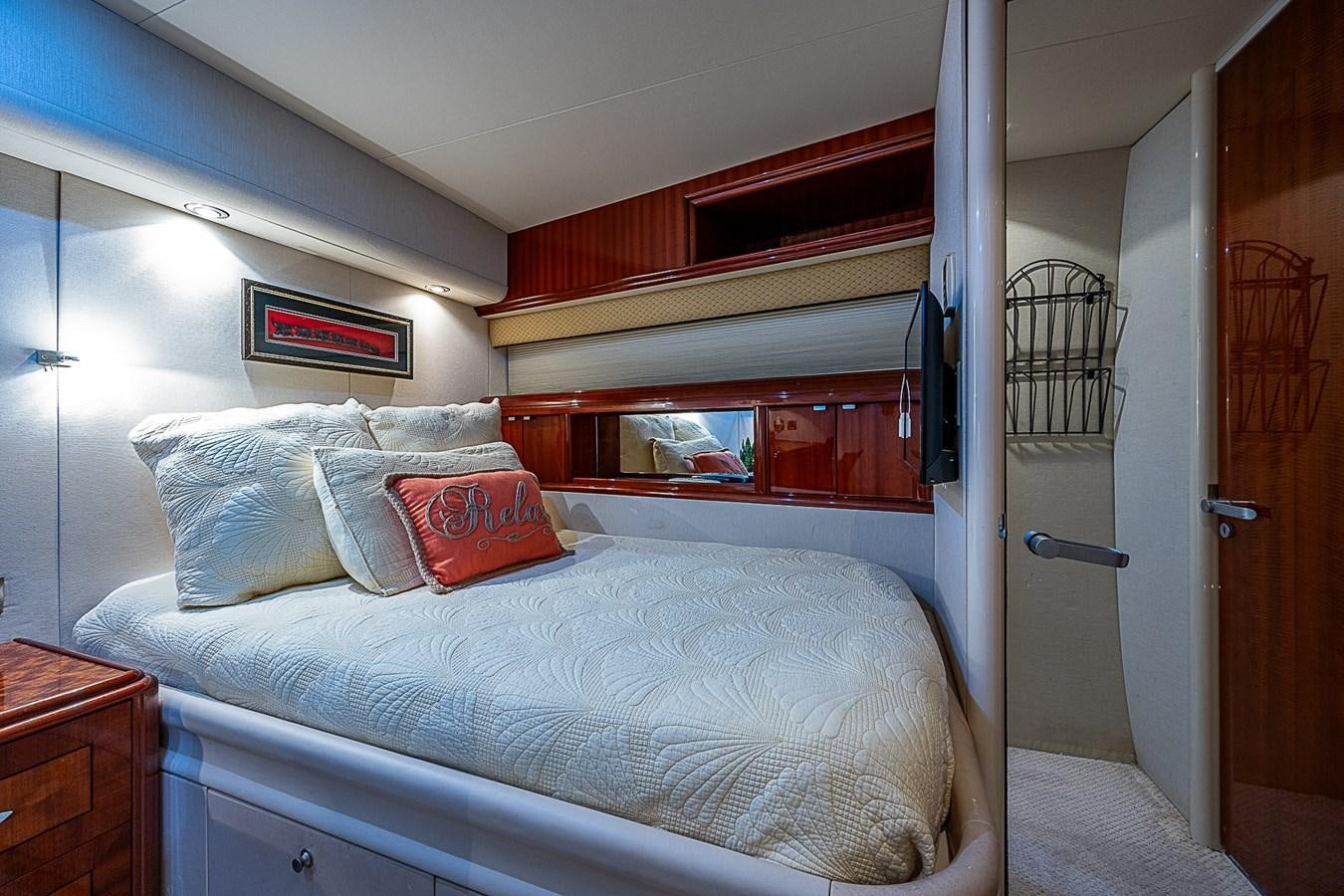 a bed with a white cover and red pillows aboard FINALLY Yacht for Sale