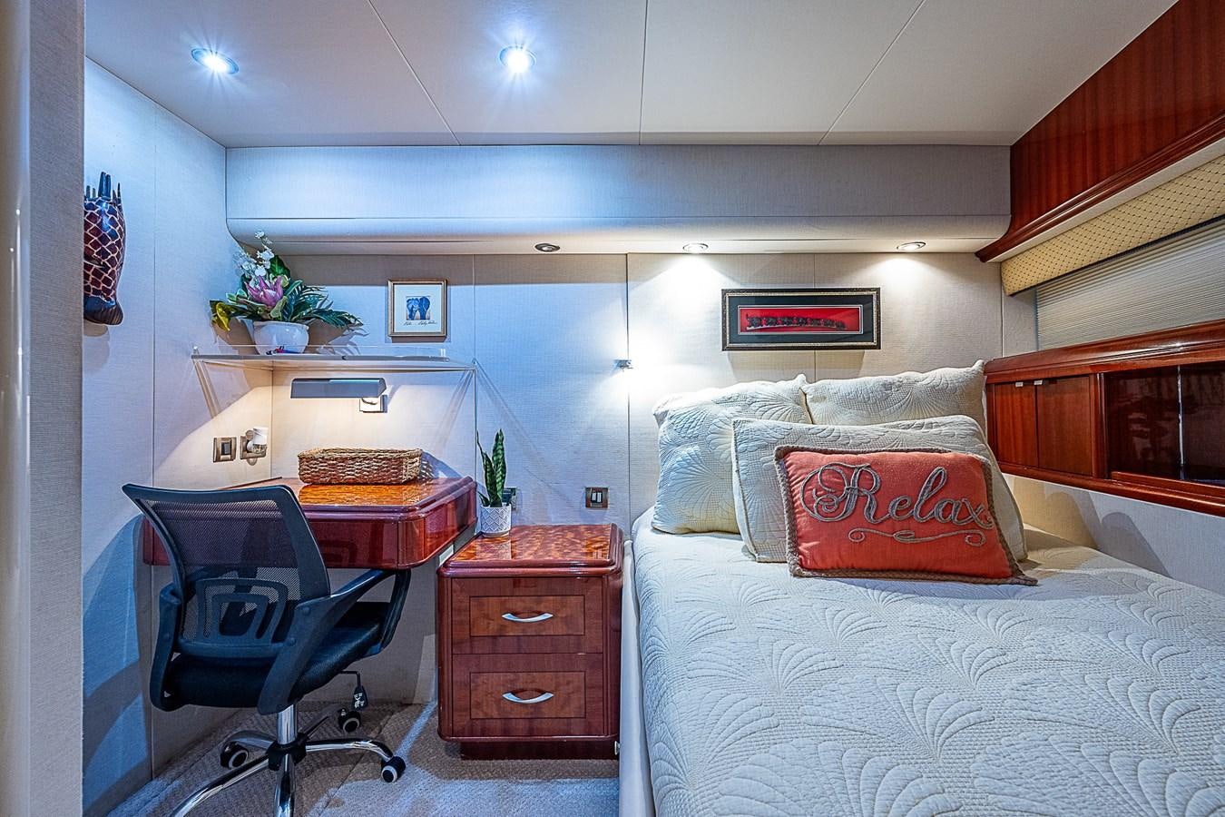 a bedroom with a bed and desk aboard FINALLY Yacht for Sale