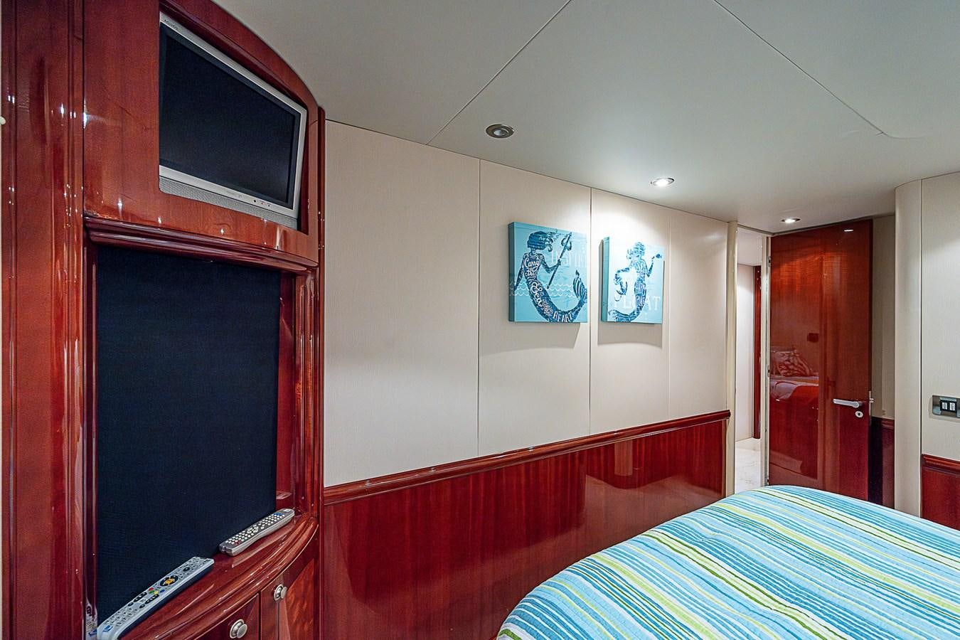 a bedroom with a bed and a television on the wall aboard FINALLY Yacht for Sale