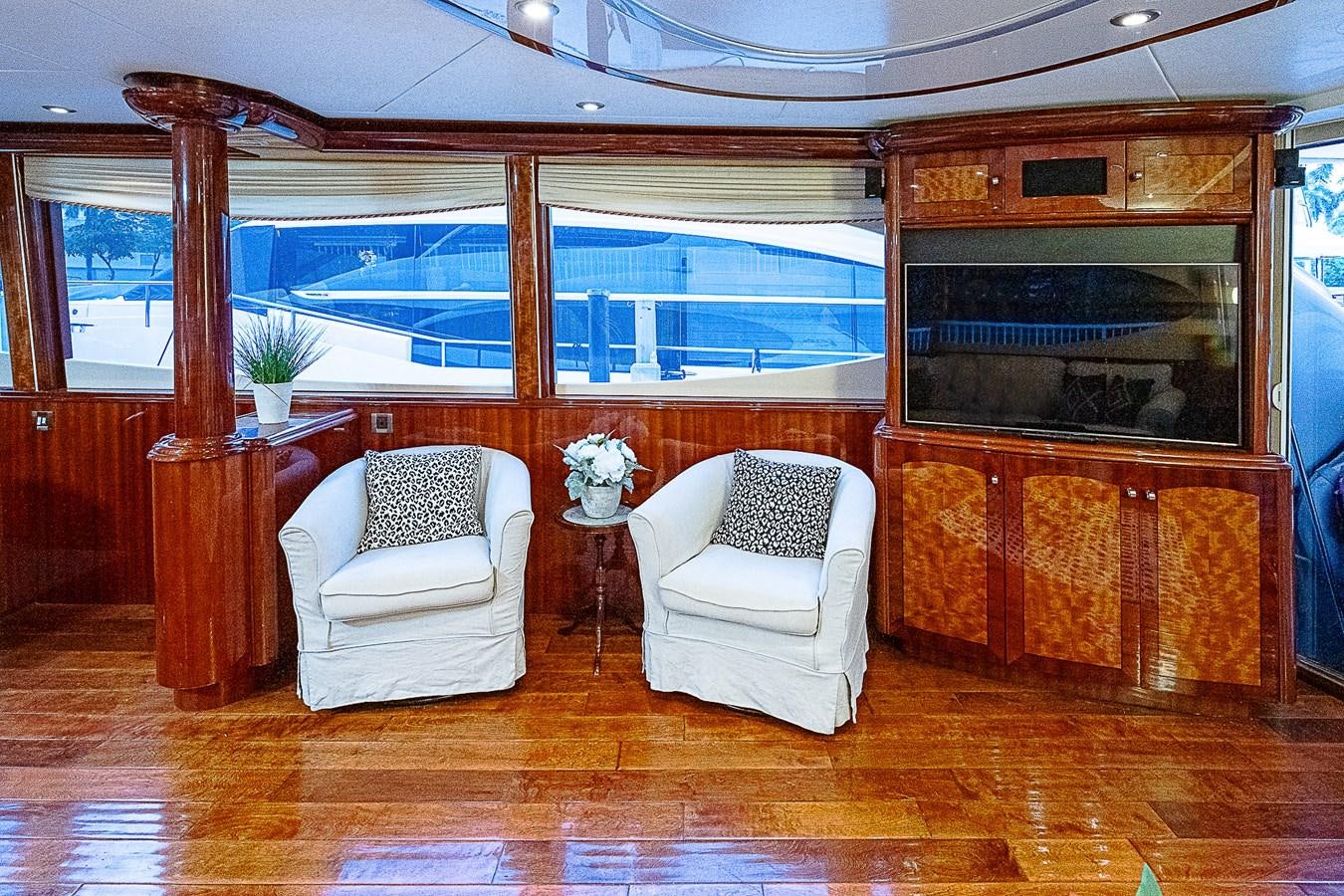 a room with a fireplace and chairs aboard FINALLY Yacht for Sale
