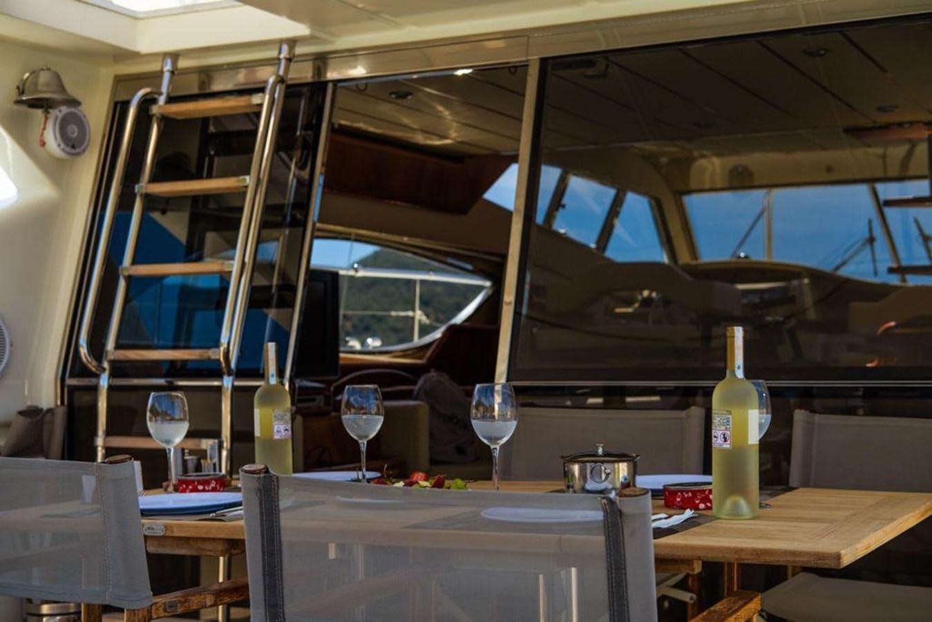 a table with wine glasses and bottles aboard FERRETTI 760 Yacht for Sale