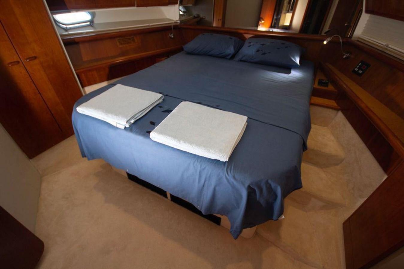 a bed with a blue sheet aboard FERRETTI 760 Yacht for Sale